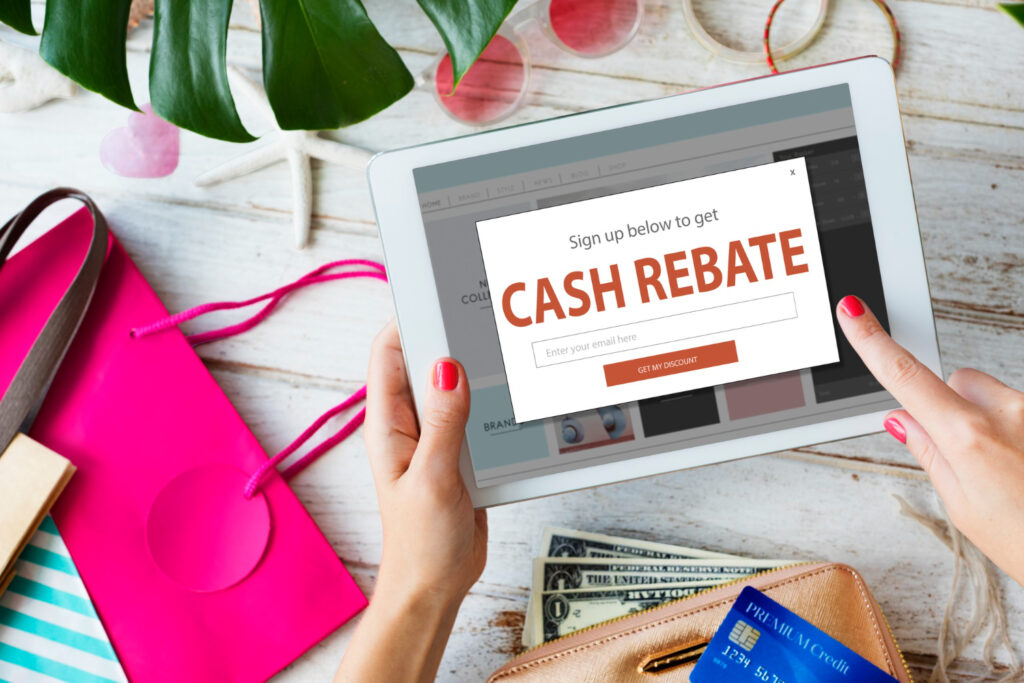 Tablette affichant une offre de cashback entourée d'articles de shopping et d'une carte bancaire.