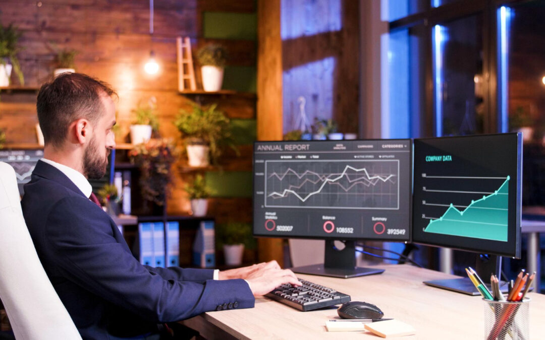Expert analysant des graphiques de performance et des rapports financiers sur double écran